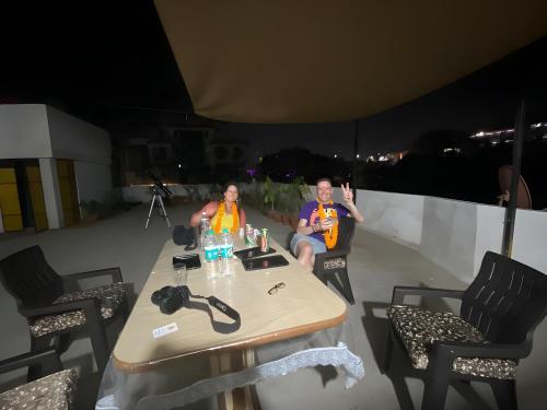two people sitting at a table on a roof at Umaid Niwas Homestay in Jaipur