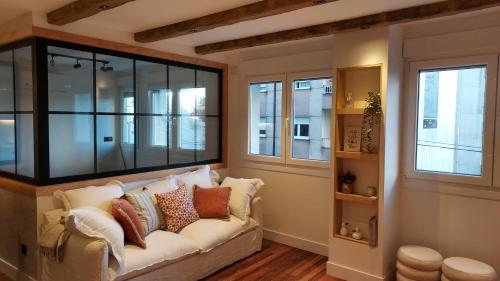 a living room with a couch and windows at Apartamento Atlantico Pontus Veteris in Pontevedra