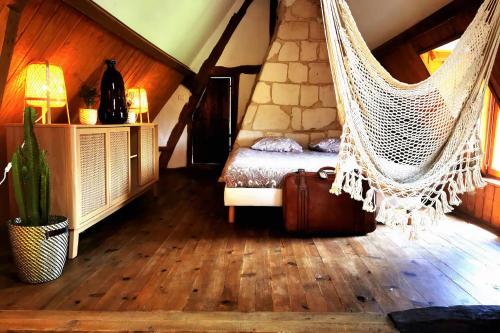 a hammock in a room with a bed and a suitcase at Domaine de la Papeterie - 25 minutes Deauville Honfleur in Bonneville-la-Louvet