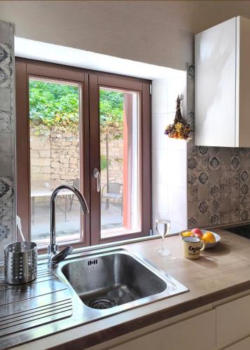 a kitchen with a sink and a window at Old town stone house in Pula
