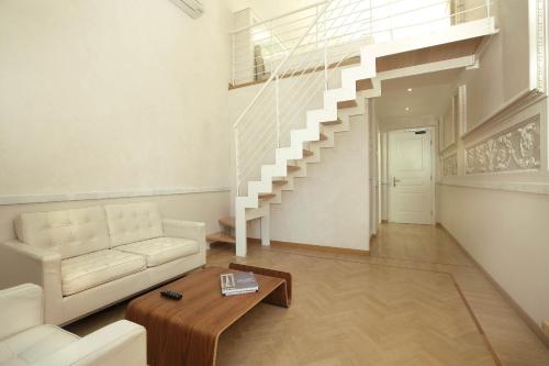 a living room with a white couch and stairs at Hotel Le Nuvole Residenza d'Epoca in Genoa