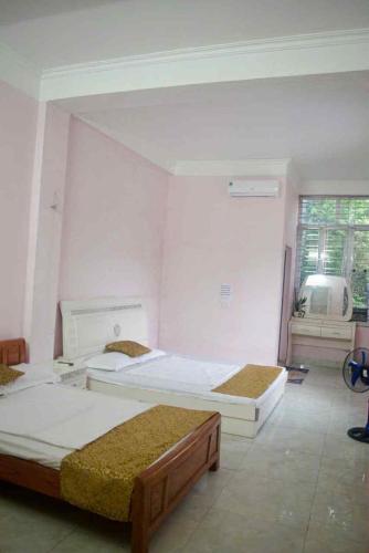 a room with two beds and a window at Nhà nghỉ Việt Anh 123 in Ha Long