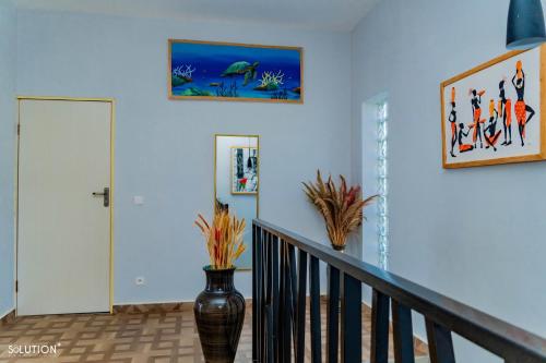 a hallway with blue walls and a staircase with a vase at Villa CasaCocoa in Hell-Ville