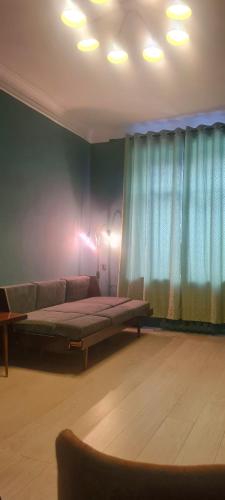 a bedroom with a bed and a couch in a room at Opera in Bishkek