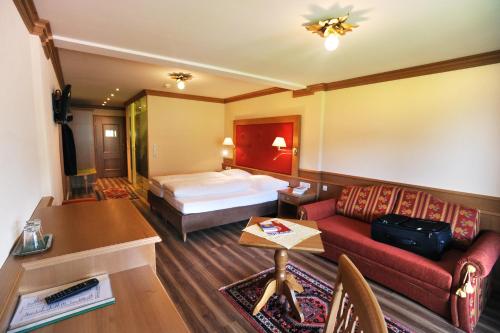 a hotel room with a bed and a couch at Das Pfandler in Pertisau