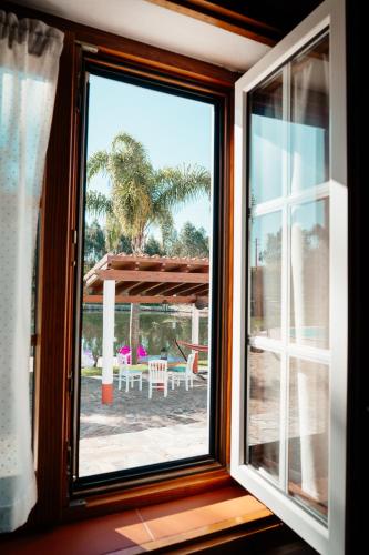 an open window with a view of a patio at Herdade do Sardanito da Frente in Zambujeira do Mar