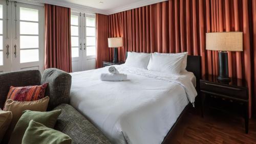 a hotel room with a large bed and a chair at MIRANAMIN NEST Elegant Home in MiraNila Heritage Compound, Pet Friendly, with Rooftop, Kitchens - Perfect for Reunions, Team Building in Manila