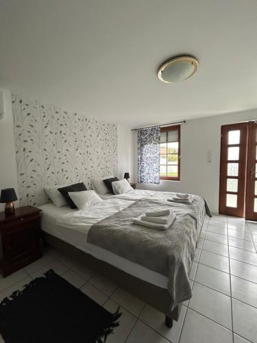a bedroom with a large bed with towels on it at Főnix Apartmanház in Vonyarcvashegy