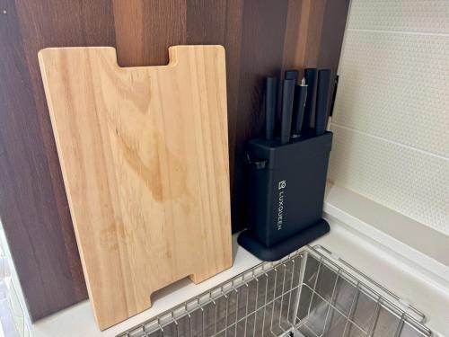 a corner of a kitchen with a wooden cutting board at Masion Sanbang Jeju in Seogwipo