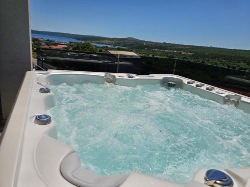 a jacuzzi tub with blue water in a balcony at Villa Madison in Posedarje
