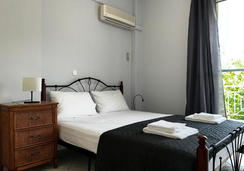 a bedroom with a bed and a dresser and a window at Sur La Mer - SeaSide Apartments in Mavrovoúnion