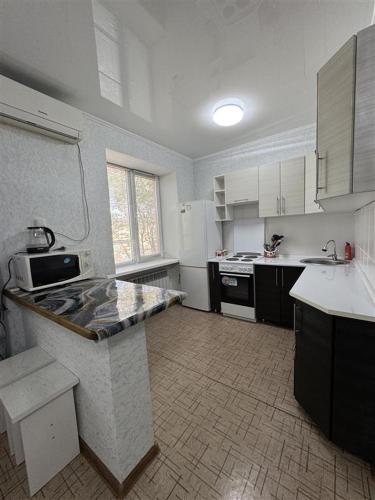 a kitchen with white cabinets and a counter top at Однокомнатная Квартира 3 in Balqash