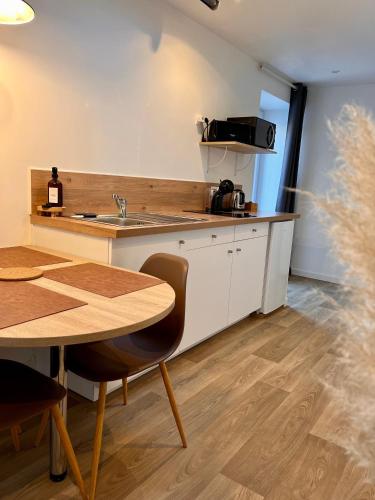 a kitchen with a table and a counter top at Le Quarante cinq -6 in Laval