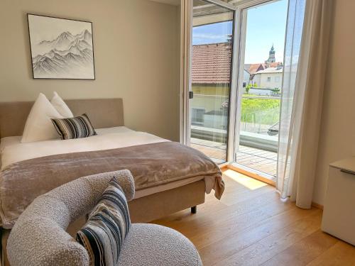 a bedroom with a bed and a sliding glass door at "SEVEN" Premium Apartments Seekirchen in Seekirchen am Wallersee