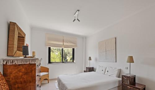 セジンブラにあるBmyGuest - Sesimbra Palames Beach & Pool Apartmentのベッドと窓のある白い寝室