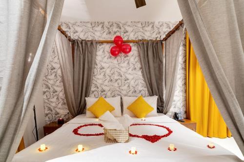 Un dormitorio con dos corazones sobre una cama con globos. en Jacuzzi Cove in Bangalore Rio, en Denkanikota