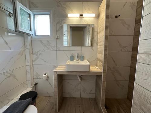 a bathroom with a sink and a mirror at Estia House 1-2 in Nikiti
