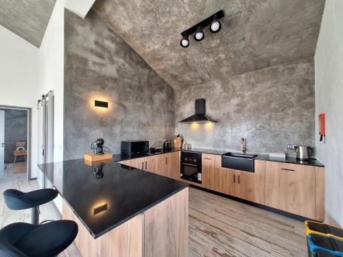 a kitchen with a black counter top and wooden cabinets at Central Lava 27 Apartment in Madalena