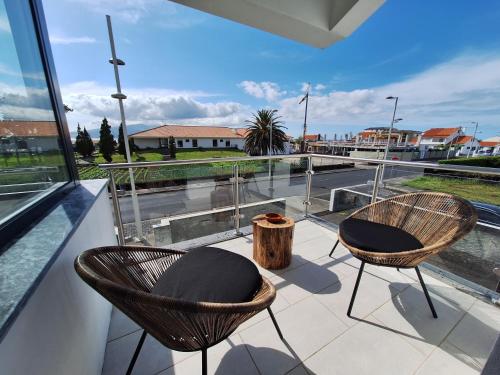 a balcony with two chairs and a view of the street at Central Lava 27 Apartment in Madalena