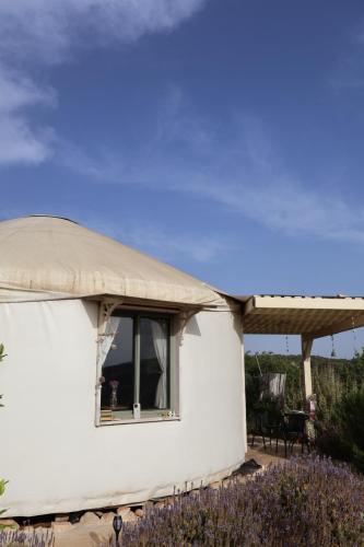 a yurt with a window and a table and chairs at צלילי השקט- היורט מול הנוף in Gita