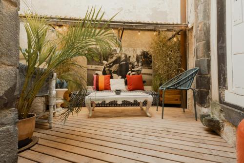 a patio with a couch and some plants at Duplex 8 pers 103m2 #MaisonSavaron in Clermont-Ferrand