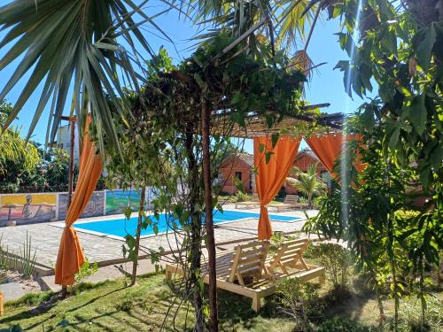 a resort with a swimming pool with orange umbrellas at Le jardin des délices in Mahajanga