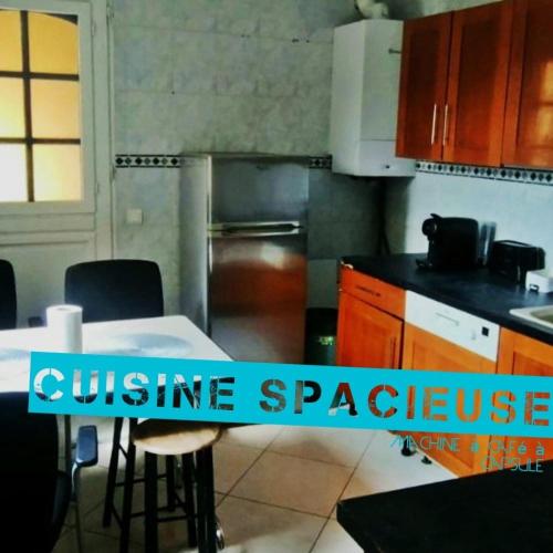 une cuisine avec une table et des chaises dans l'établissement Maison 45 min de la Tour Eiffel, à Saint-Denis