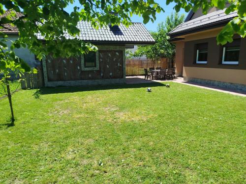 a yard with two birds sitting on the grass at Villa Orhan in Bihać