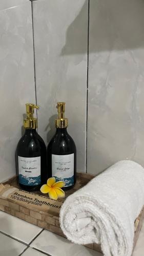 two bottles of soap on a wooden tray with a towel at Mustika Ocean Lodge in Gili Islands