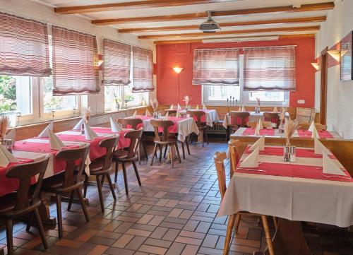 a restaurant with tables and chairs in a room at Pension Altes Backhaus in Herzogenaurach
