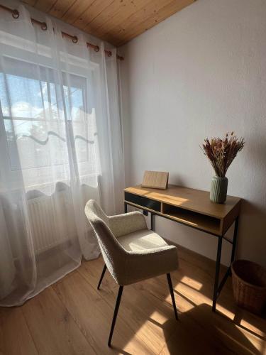 Cette chambre dispose d'un bureau et d'une chaise. dans l'établissement Home Sweet Home - Gemütliche Ferienwohnung, à Soyen