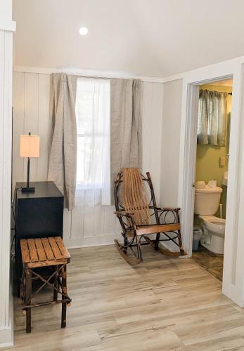 a room with two chairs and a table and a toilet at Hinckleys Dreamwood Cottages in Bar Harbor