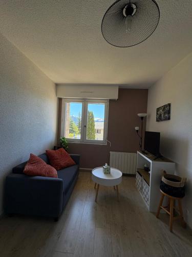 un salon avec un canapé bleu et une table dans l'établissement Appartement T2 Font-Romeu, à Font-Romeu-Odeillo-Via