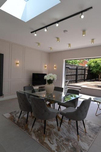 a dining room with a glass table and chairs at Luxury House for Families and Contractors, NamisSuites Serviced Apartment - Farnborough in Farnborough