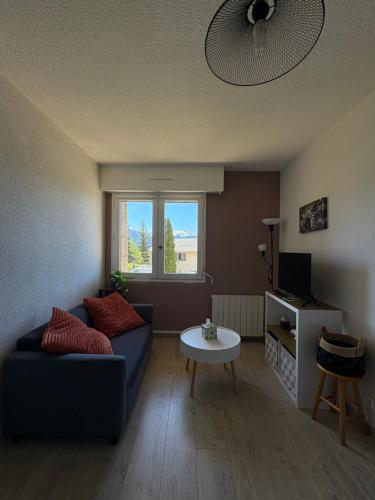un salon avec un canapé bleu et une table dans l'établissement Appartement T2 Font-Romeu, à Font-Romeu-Odeillo-Via