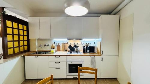 a kitchen with white cabinets and a table and chairs at Ampio Appartamento su 2 Livelli nel Centro Storico, Ideale per Coppie o Gruppi da 2 a 5 Persone in Fiuggi
