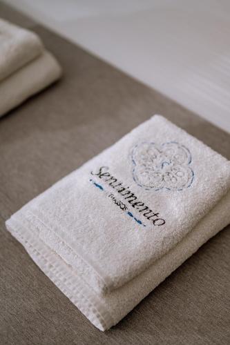 a white napkin with a flower on it on a table at Sentimento in Prinos
