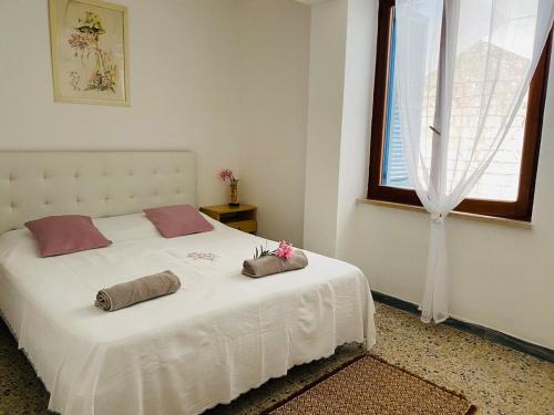 a bedroom with a white bed with two pillows on it at Apartment in Villa under Grand Palm Tree & Garden in Porto Alabe