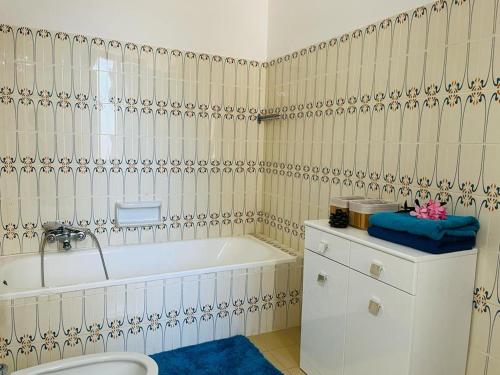 a bathroom with a bath tub and a toilet at Apartment in Villa under Grand Palm Tree & Garden in Porto Alabe