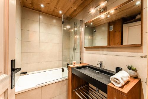 une salle de bain avec un lavabo et une baignoire dans l'établissement Alpin chic au cœur de Chamonix, à Chamonix-Mont-Blanc