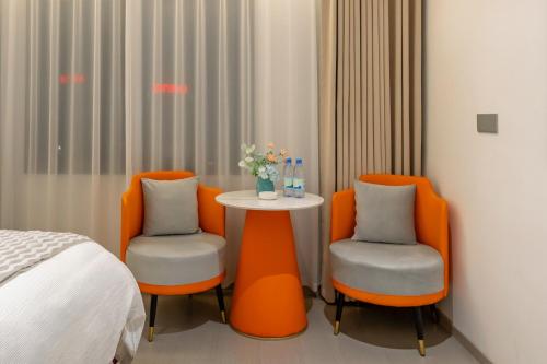 two orange chairs and a table in a room at 一花一树音影民宿Tian Men mountian Branch in Wangjiazhai