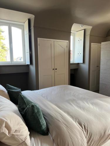 a bedroom with a large white bed with green pillows at The Cotton Suites B&B in Deerlijk