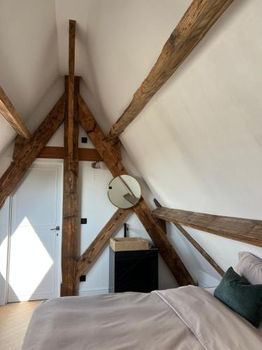 a room with a bed and a mirror at The Cotton Suites B&B in Deerlijk