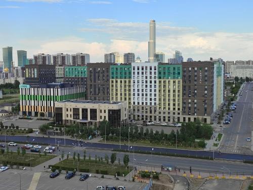 uitzicht op een stad met gebouwen en een parkeerplaats bij Tandau apartment in Taldykolʼ