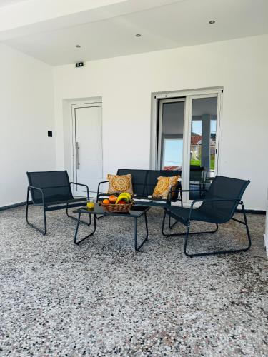 a living room with two chairs and a table with fruit on it at Massalia Suites in Agios Stefanos