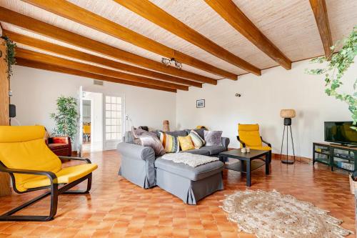 a living room with a gray couch and yellow chairs at Gîte du Dolmen in Guiscriff