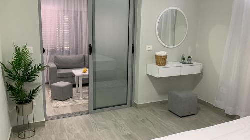 bagno con doccia, lavandino e specchio di Dionis House a Shkodër