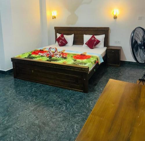 a bedroom with a large bed with red pillows at Vegetable Garden House in Adams Peak