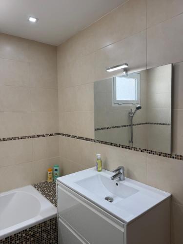 une salle de bain avec un lavabo et un miroir dans l'établissement Magnifique appartement vacances proche de la mer, à Nice
