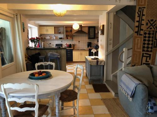 une cuisine et un salon avec une table et des chaises dans l'établissement CAP vacances - GR34, à Cléden-Cap-Sizun